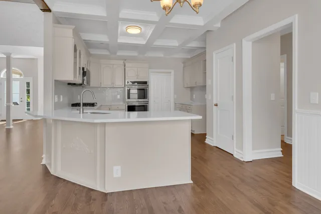 a kitchen with stainless steel appliances a sink a stove a refrigerator and cabinets