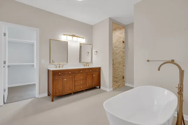 a spacious bathroom with a tub sink and mirror
