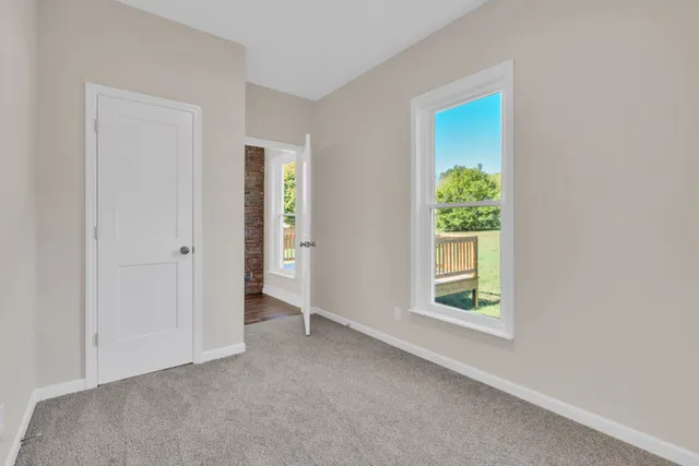 an empty room with windows and closet
