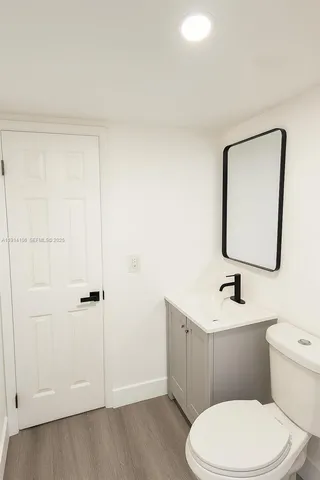 a bathroom with a toilet a sink and mirror