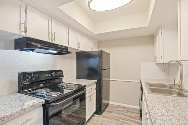 a kitchen with granite countertop a stove and a refrigerator
