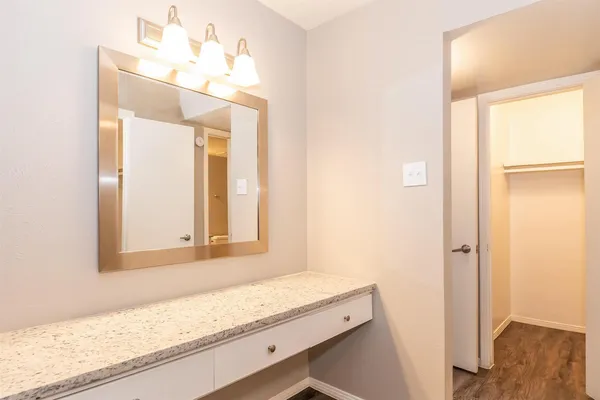 a bathroom with a granite countertop sink and a mirror