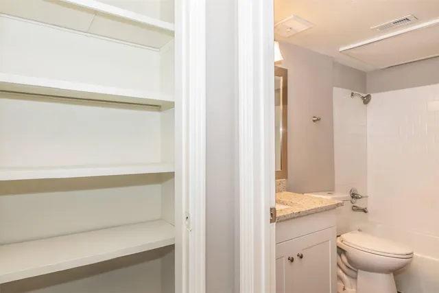 a bathroom with a granite countertop sink mirror vanity and toilet