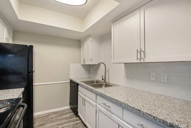 a kitchen with granite countertop a sink stainless steel appliances and cabinets