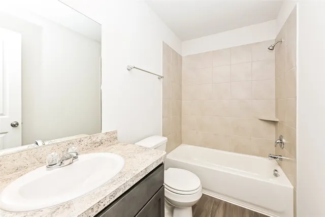 a bathroom with a granite countertop sink a toilet and bathtub