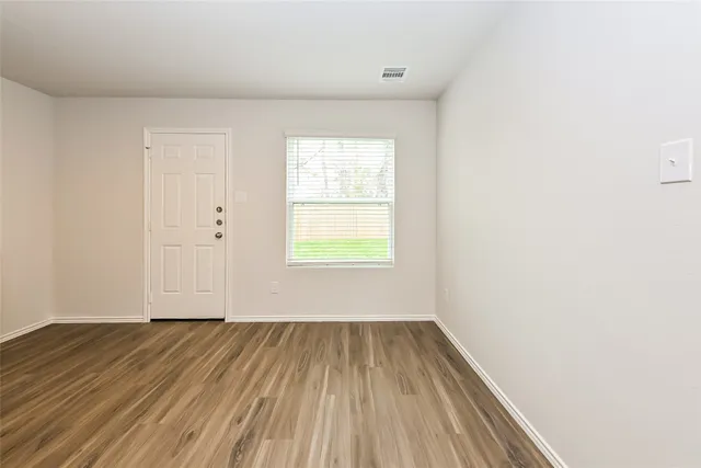a view of a room with wooden floor and window