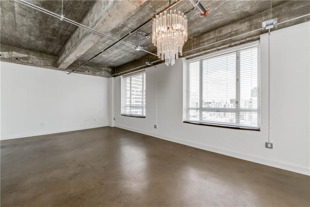 710 Colorado Street, Unit G9 Austin, TX 78701 - Photo 9 of 25 Lofty ceilings complement durable concrete flooring in this well-lit living space.