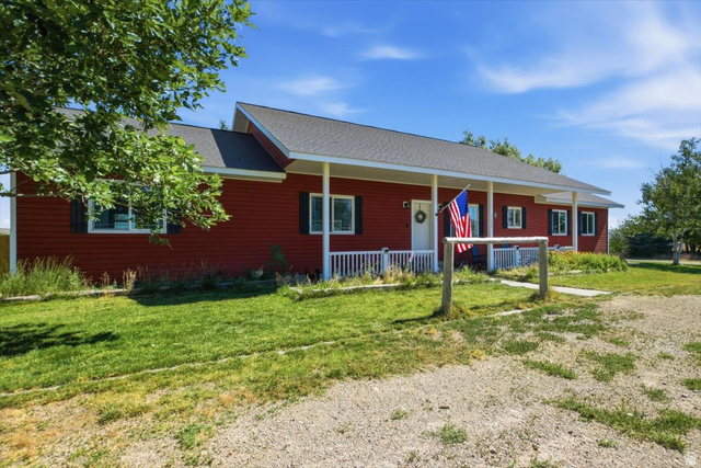 1634 West Arimo Road Arimo, ID 83214 - Photo 85 of 89 Red siding exterior with a covered front porch featuring white railings and columns