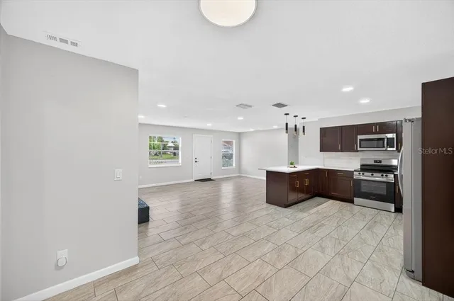 a view of a kitchen with furniture and a refrigerator
