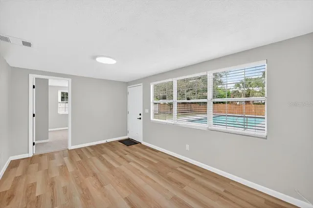 a view of an empty room with exposed radiator and window