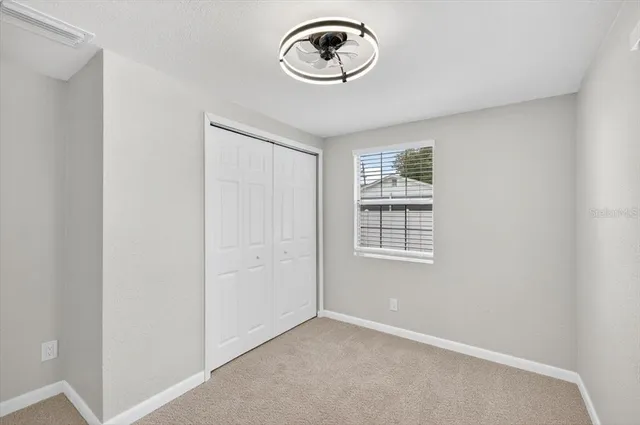 a view of an empty room and a ceiling fan window