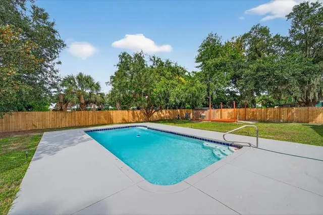 an aerial view of residential houses with outdoor space and trees
