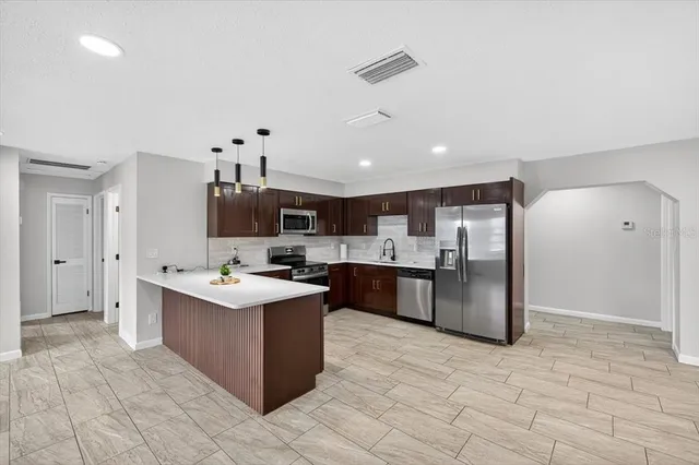 a large kitchen with stainless steel appliances granite countertop a stove and a sink