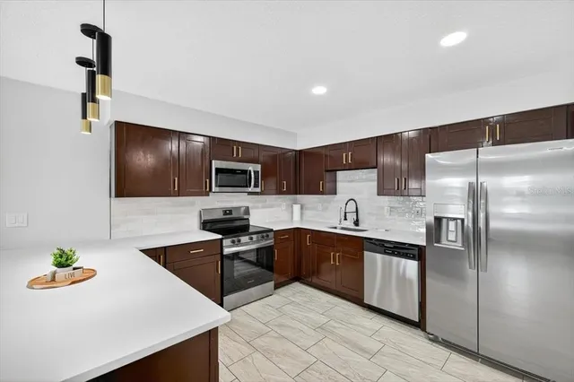 a kitchen with stainless steel appliances a sink and a refrigerator
