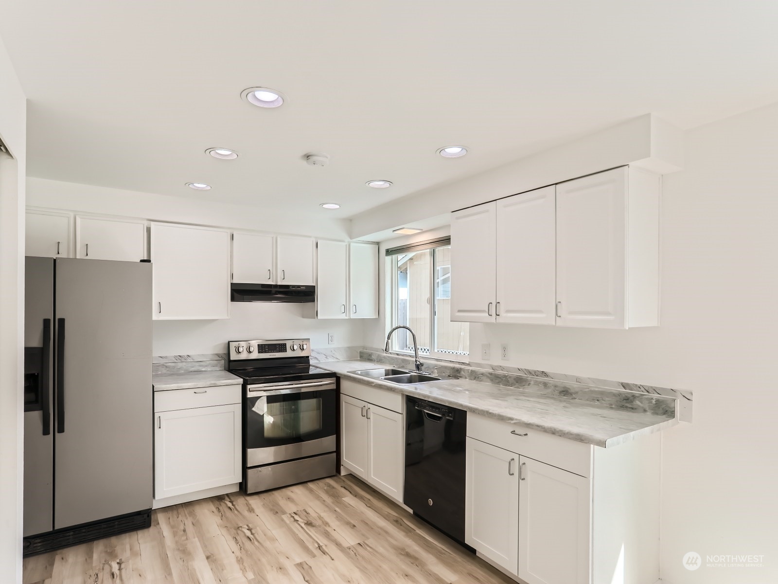 9211 3rd Place Southeast Everett, WA 98208 - Photo 7 of 20 a kitchen with stainless steel appliances granite countertop white cabinets stove a sink and dishwasher