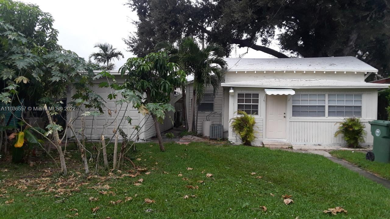 1759 Northwest 18th Terrace Miami, FL 33125 - Photo 3 of 10 a view of a white house with a big yard and large tree