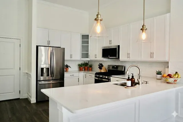 a kitchen with refrigerator a microwave a stove and white cabinets