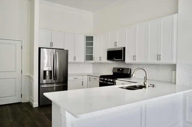 a kitchen with stainless steel appliances granite countertop a refrigerator stove and a sink