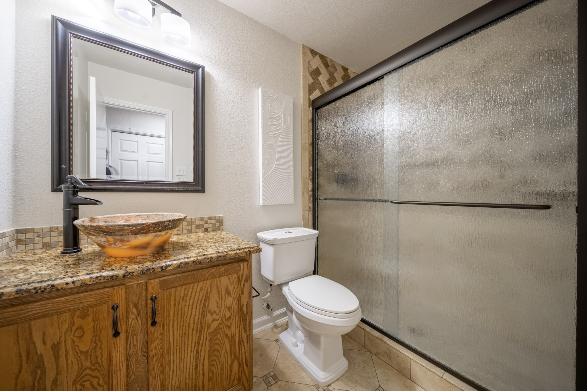 1302 Newbury Street Georgetown, TX 78626 - Photo 17 of 20 a bathroom with a granite countertop toilet sink and mirror