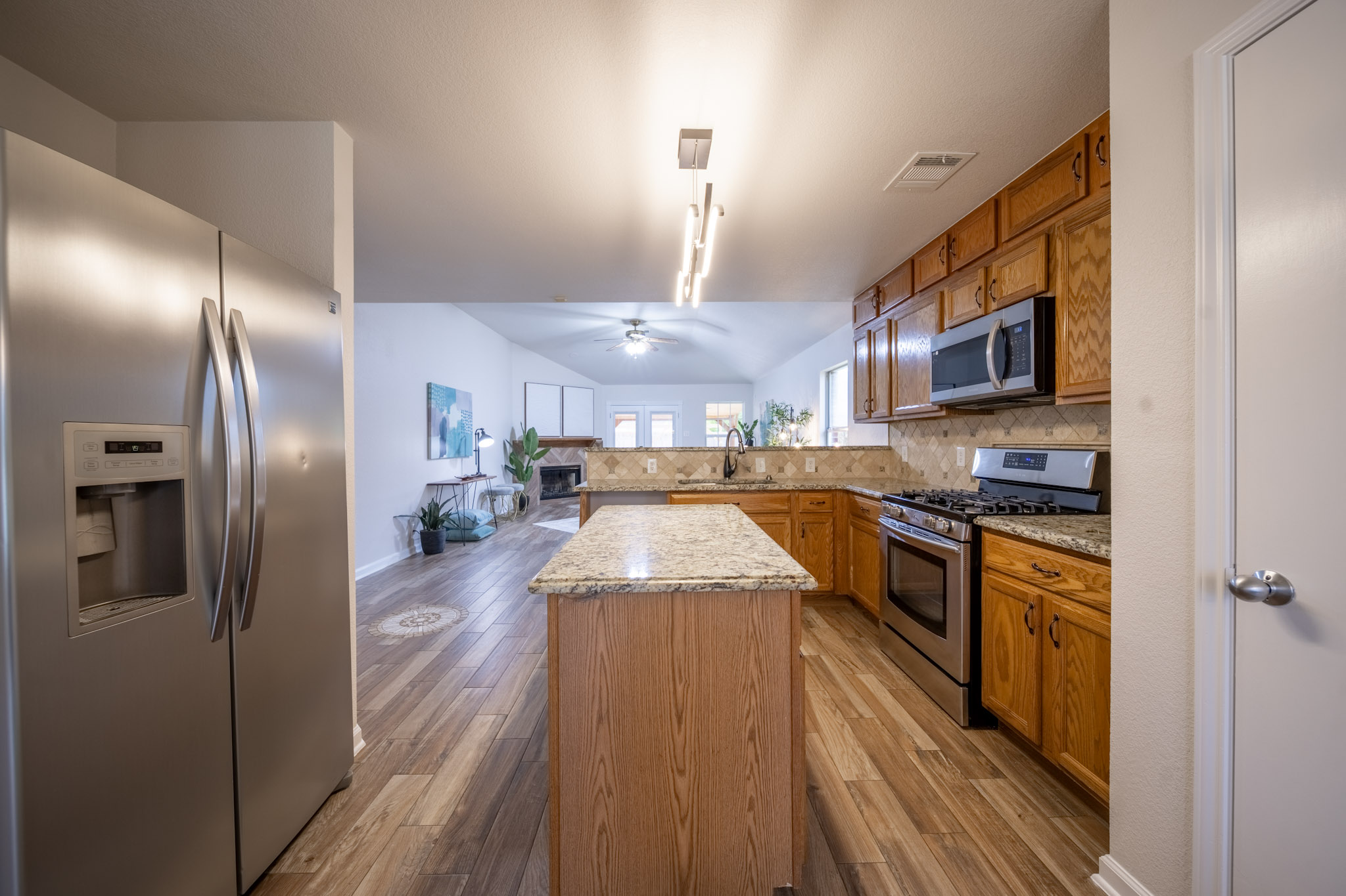 1302 Newbury Street Georgetown, TX 78626 - Photo 6 of 20 a large kitchen with stainless steel appliances granite countertop a refrigerator a oven a sink with wooden floors and cabinets