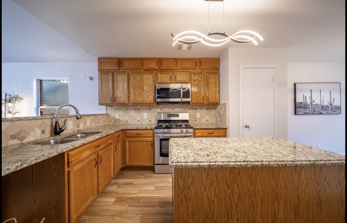 1302 Newbury Street Georgetown, TX 78626 - Photo 7 of 20 a kitchen with stainless steel appliances granite countertop a sink stove and refrigerator