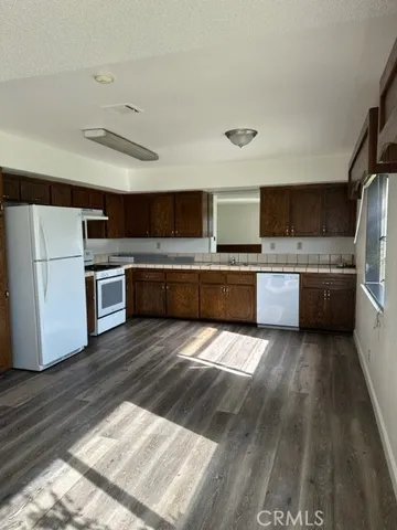 a large kitchen with wooden floors and stainless steel appliances