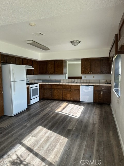 a large kitchen with wooden floors and stainless steel appliances