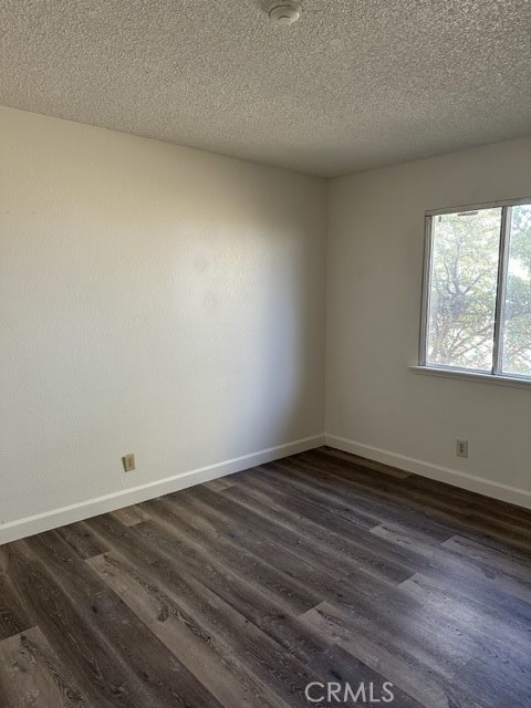 14952 Ritter Street, Unit C Victorville, CA 92394 - Photo 5 of 8 an empty room with wooden floor and windows