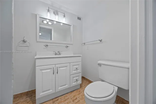 a bathroom with a toilet a sink a vanity and mirror