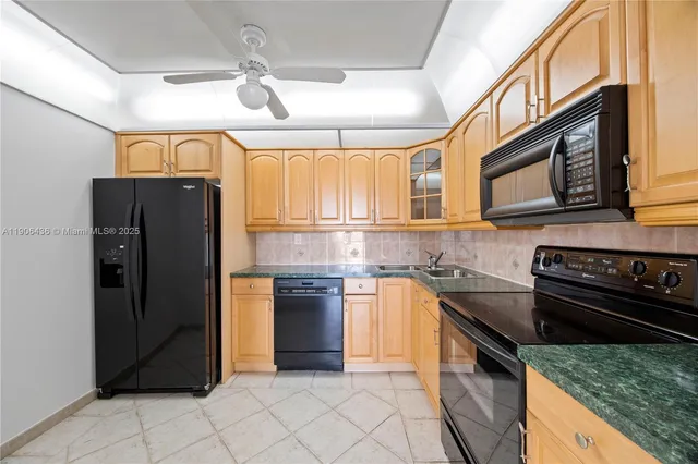 a kitchen with granite countertop a stove cabinets and refrigerator