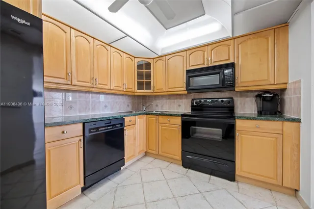 a kitchen with granite countertop a stove top oven microwave and cabinets