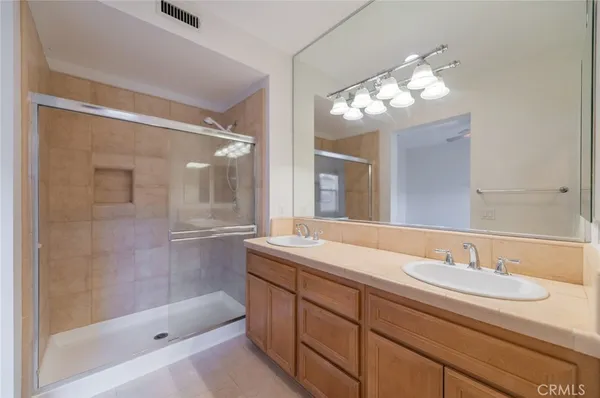 a bathroom with a sink double vanity granite tub and a mirror