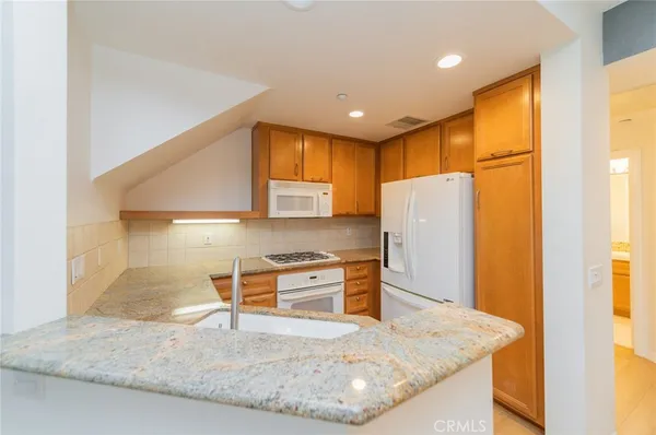 a kitchen with stainless steel appliances granite countertop a sink refrigerator and microwave