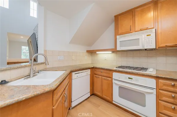 a kitchen with granite countertop cabinets stainless steel appliances and a sink