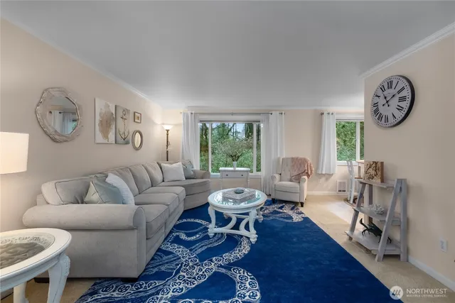 a living room with furniture a window and a clock