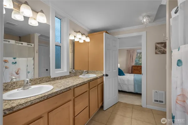 a en suite bathroom with a double vanity sink and a mirror