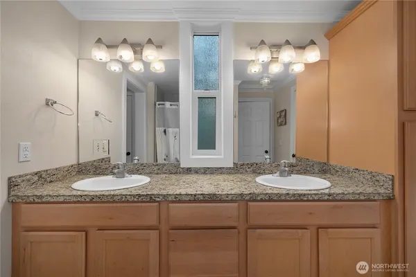 a bathroom with a granite countertop sink a mirror and a shower