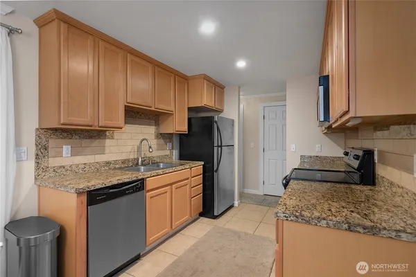 a kitchen with stainless steel appliances granite countertop a sink stove and refrigerator