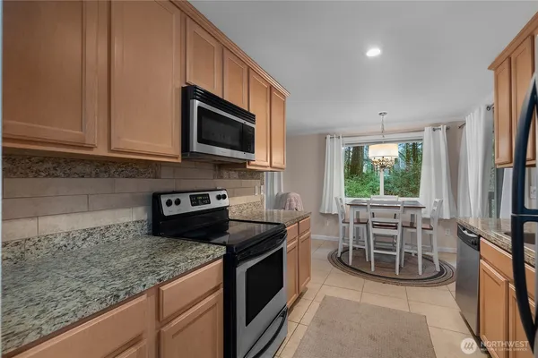 a kitchen with granite countertop a sink and steel appliances