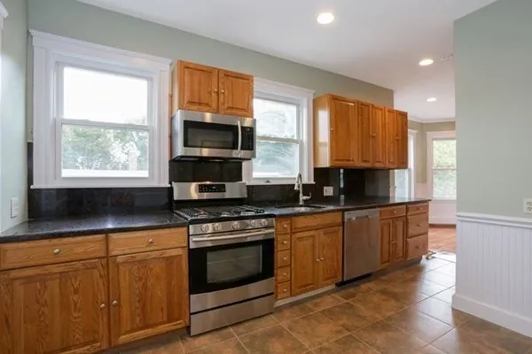 a kitchen with stainless steel appliances granite countertop a stove a sink and a microwave