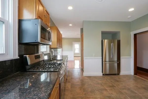 a kitchen with stainless steel appliances granite countertop a refrigerator and a stove