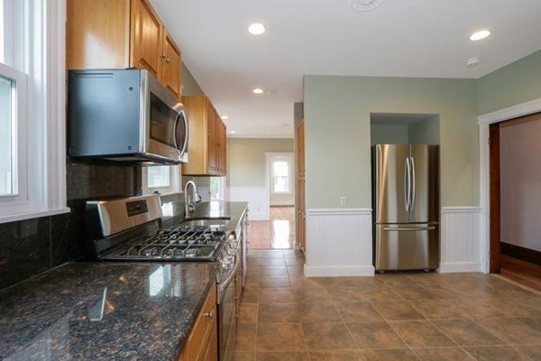 12 White Avenue, Unit 3 Brookline, MA 02467 - Photo 10 of 24 a kitchen with stainless steel appliances granite countertop a refrigerator and a stove