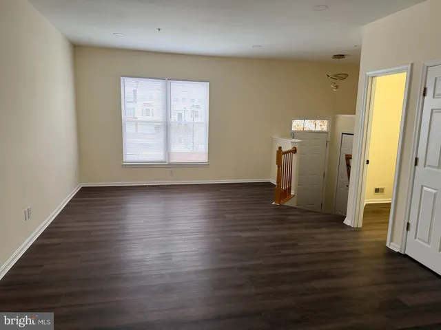 an empty room with wooden floor and a window