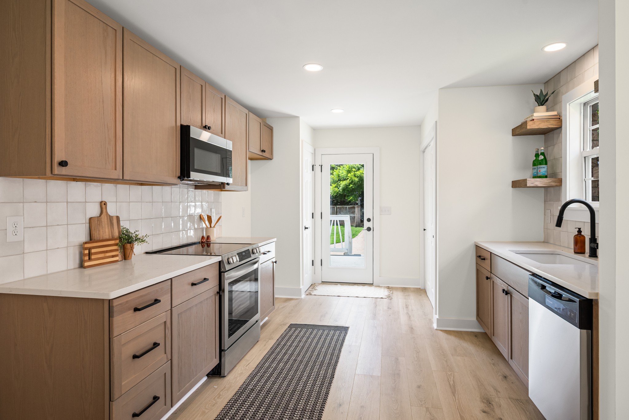 1815 3rd Avenue North Nashville, TN 37208 - Photo 2 of 44 a kitchen with stainless steel appliances a sink dishwasher a stove top oven a refrigerator with wooden floor and cabinets
