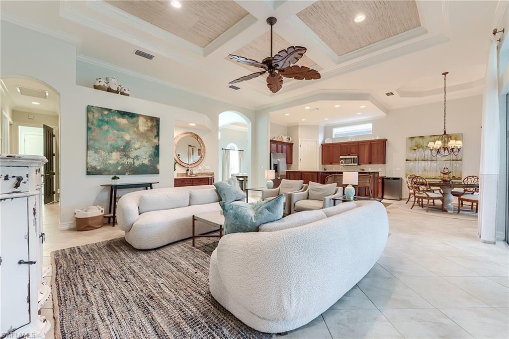 7699 Cottesmore Drive Naples, FL 34113 - Photo 13 of 37 a living room with furniture kitchen view and a chandelier