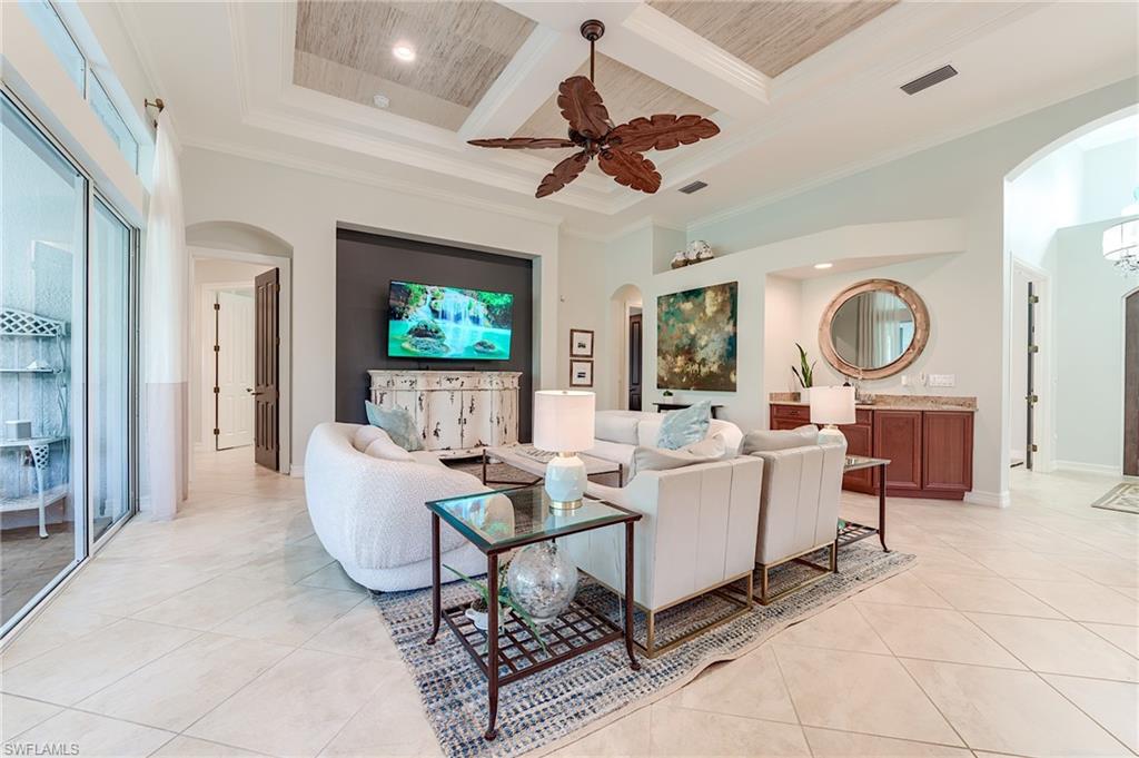 7699 Cottesmore Drive Naples, FL 34113 - Photo 15 of 37 a living room with couches a dining table and kitchen view
