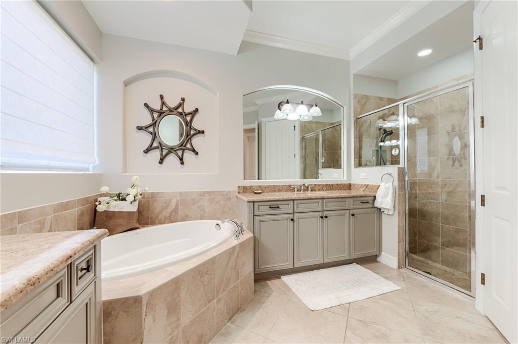 7699 Cottesmore Drive Naples, FL 34113 - Photo 20 of 37 a bathroom with a tub sink and mirror