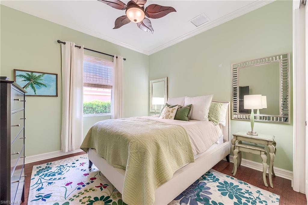 7699 Cottesmore Drive Naples, FL 34113 - Photo 25 of 37 a bedroom with a bed and a chandelier