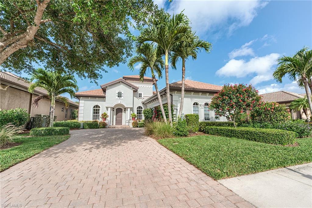7699 Cottesmore Drive Naples, FL 34113 - Photo 37 of 37 a front view of a house with a garden and trees