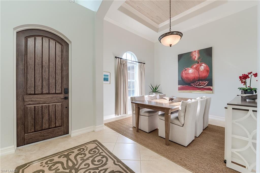 7699 Cottesmore Drive Naples, FL 34113 - Photo 6 of 37 a living room with furniture a chandelier and wooden floor